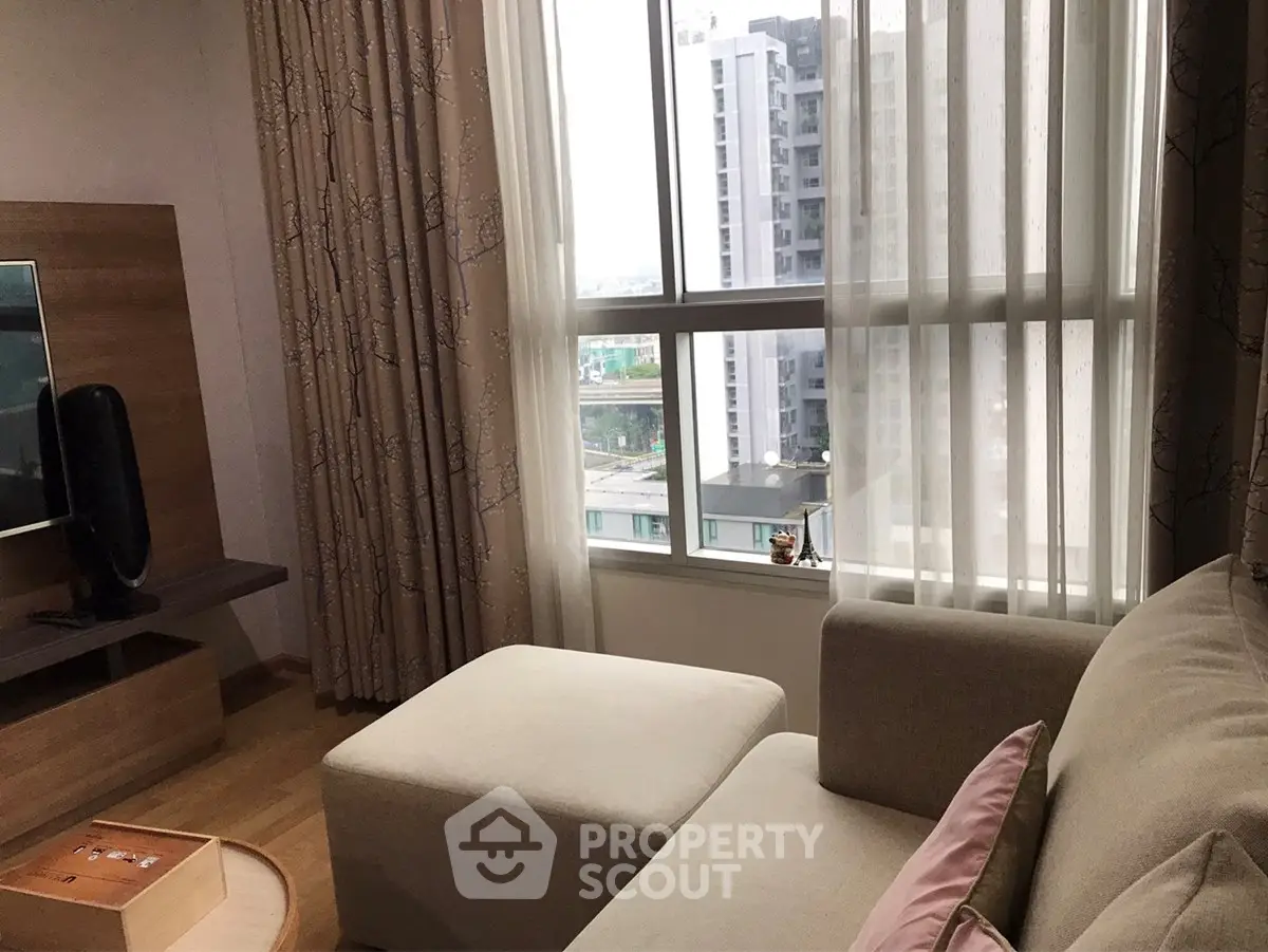 Cozy living room with modern decor and large window offering city view