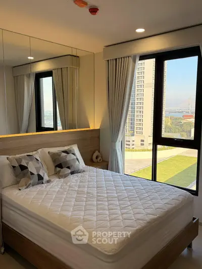 Modern bedroom with large window offering stunning city view and stylish decor.