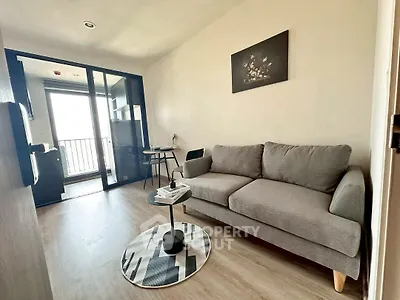 Modern living room with cozy gray sofa and stylish decor, featuring a balcony view.
