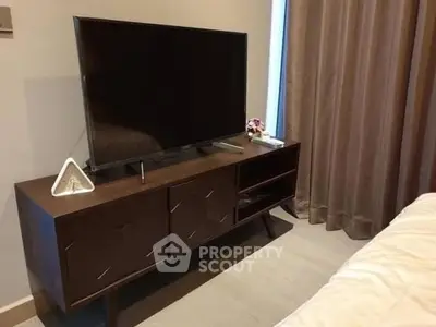 Modern bedroom with sleek TV stand and elegant curtains