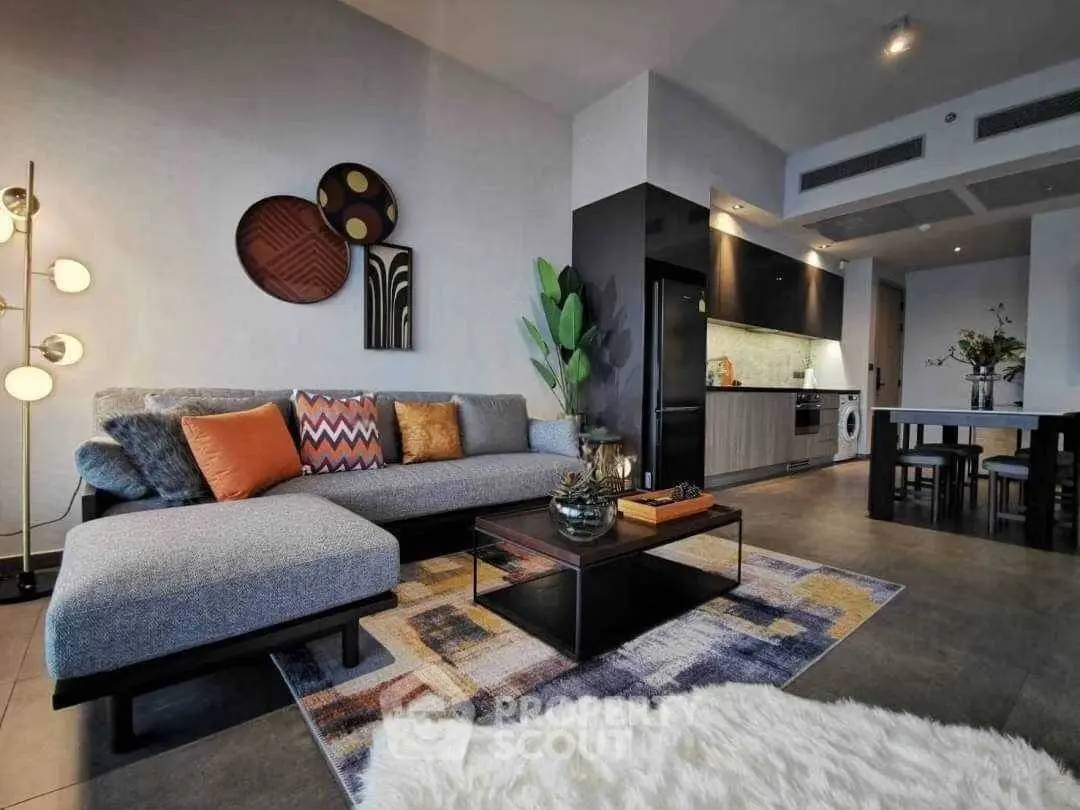 Modern living room with stylish decor, open kitchen layout, and cozy seating area.