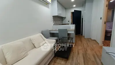 Modern studio apartment with cozy living area and stylish kitchen, featuring wooden flooring and elegant decor.
