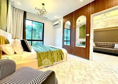 Luxurious bedroom with modern decor and large windows offering lush garden views.