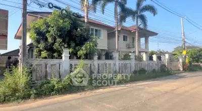 Charming suburban house with lush greenery and palm trees, perfect for family living.