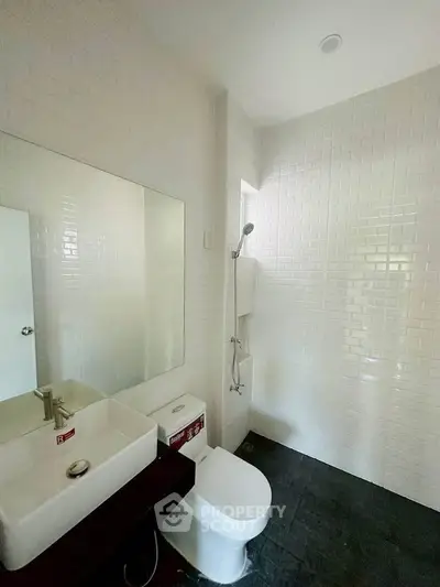 Modern bathroom with sleek white tiles and contemporary fixtures.