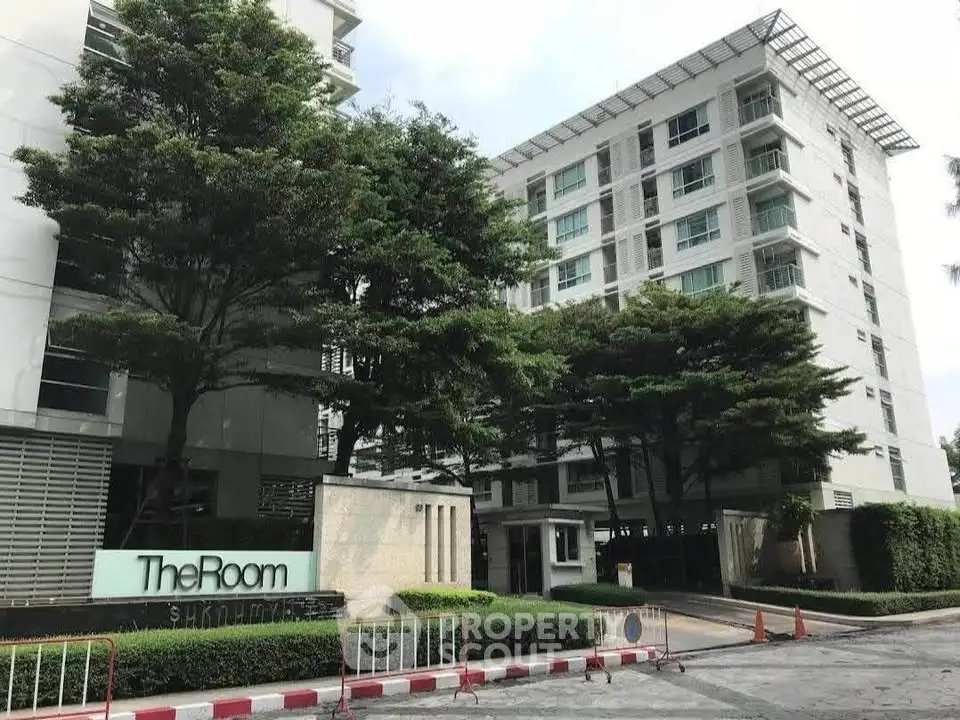 Modern condominium building with lush greenery and sleek architecture