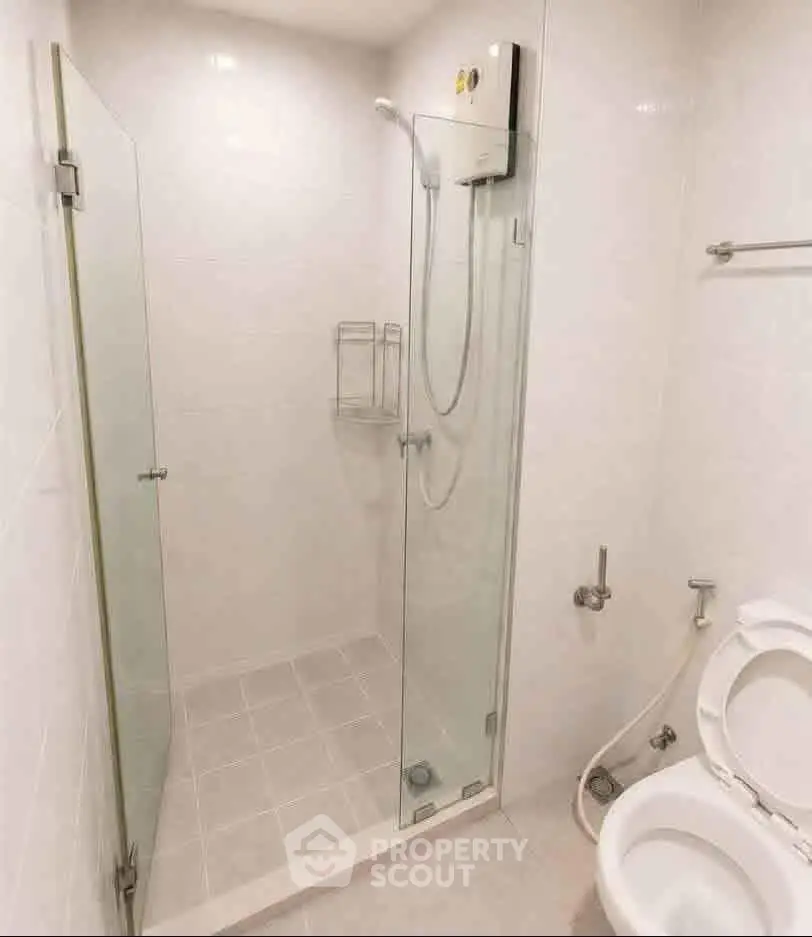 Modern bathroom with glass shower enclosure and white fixtures