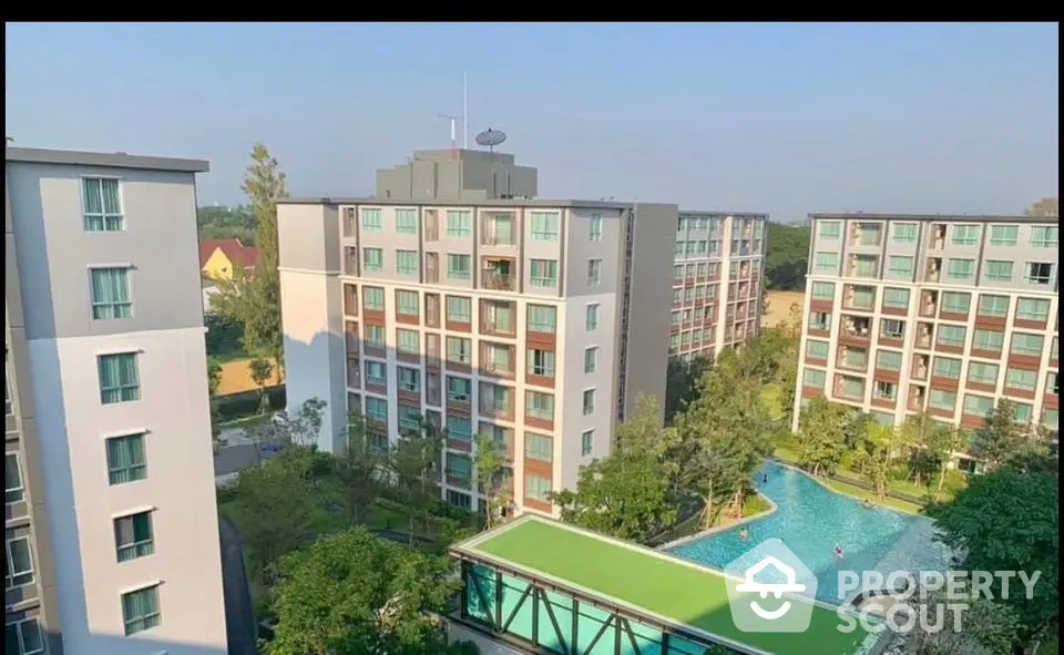 Modern apartment complex with pool and lush greenery offering serene living environment.