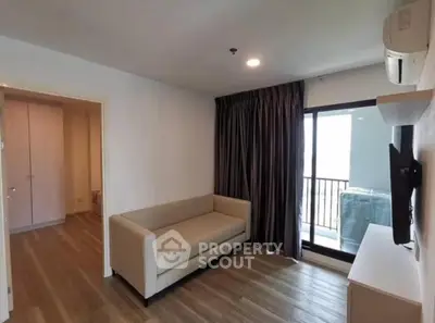 Modern living room with balcony access and sleek furnishings in a stylish apartment.