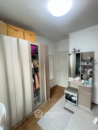 Modern bedroom with sleek storage solutions and stylish vanity area.