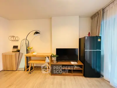Modern living room with stylish furniture and sleek black refrigerator, perfect for contemporary living.