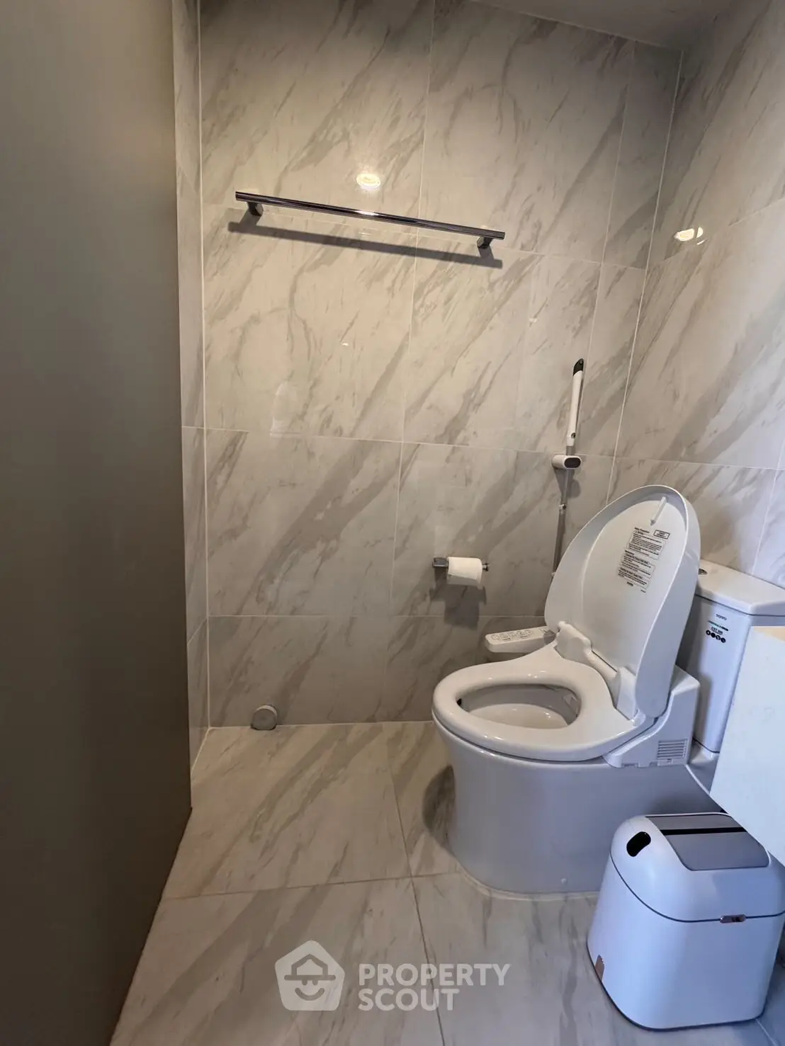 Modern bathroom with sleek marble tiles and contemporary toilet design.