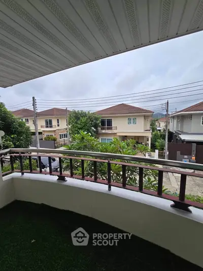 Charming balcony view overlooking suburban neighborhood with lush greenery and modern homes.