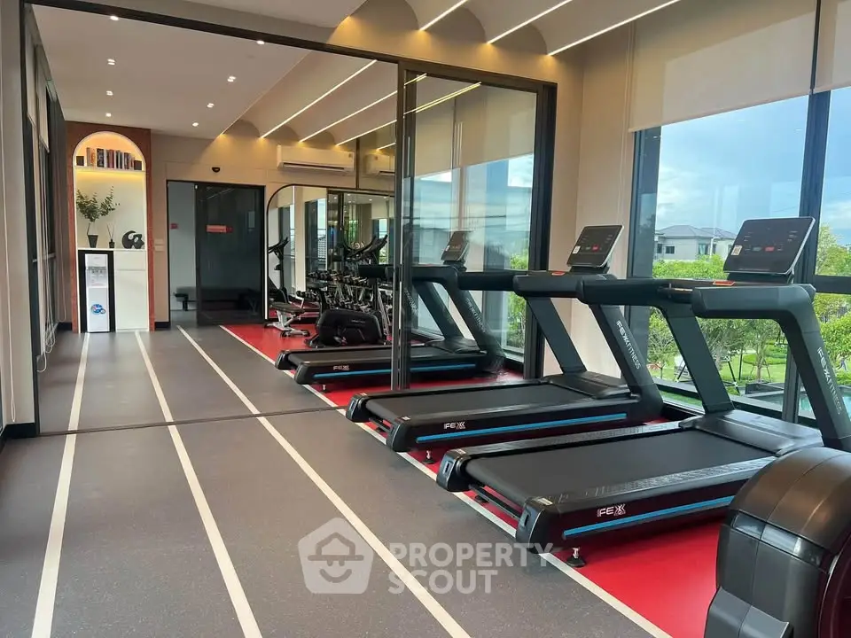 Modern gym with treadmills and large windows offering scenic views.