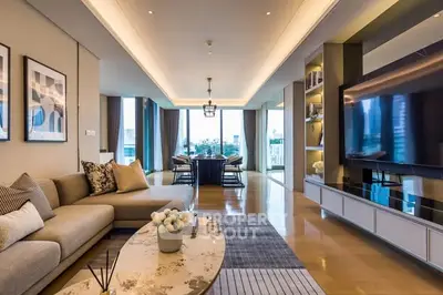 Luxurious open-plan living room with modern decor and large TV