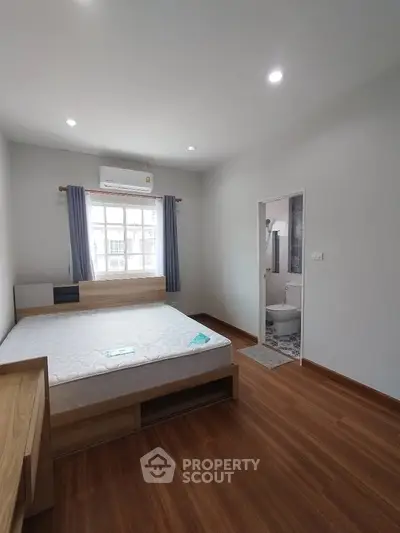 Spacious bedroom with ensuite bathroom and large window for natural light.