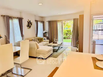 Spacious and bright living room with modern decor and garden view, perfect for family gatherings.
