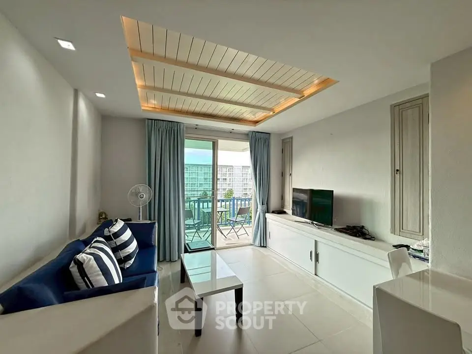 Modern living room with balcony view, featuring sleek furniture and stylish ceiling design.