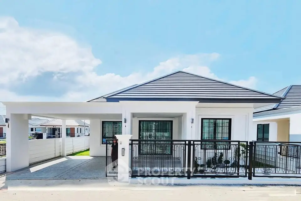 Modern single-story house with sleek design and spacious driveway in a serene neighborhood.