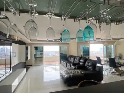 Luxurious living room with modern decor and stunning city view from large windows.