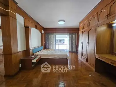 Spacious bedroom with wooden flooring and built-in wardrobe