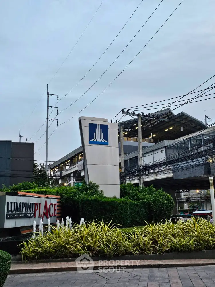 Modern Lumpini Place building exterior with lush landscaping and urban backdrop