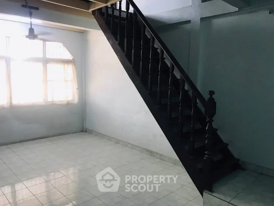 Spacious interior with elegant staircase and natural light, perfect for modern living.