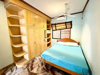 Cozy bedroom with built-in wooden wardrobe and modern ceiling fan