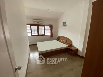 Spacious bedroom with natural light and minimalist decor in modern apartment.