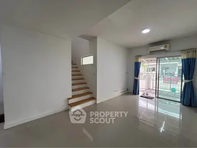 Spacious modern living room with staircase and large windows