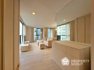 Spacious modern living room with large windows and elegant furniture in a luxury apartment.