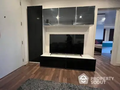 Modern living room with sleek black entertainment center and hardwood floors