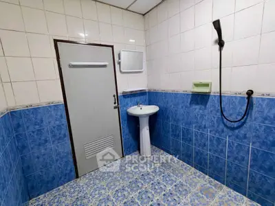 Spacious tiled bathroom with modern shower and pedestal sink