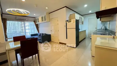 Spacious open-layout living room and kitchen with modern furnishings and large windows.