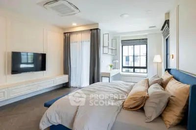Luxurious bedroom with elegant decor and large window offering natural light