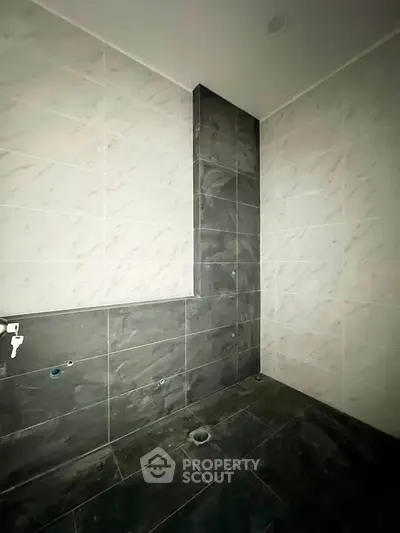 Modern bathroom under construction with sleek tile design and plumbing fixtures.