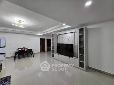 Spacious modern living room with elegant dining area and sleek TV unit.