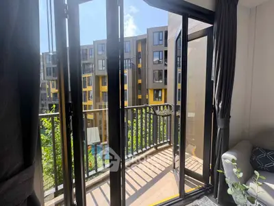 Modern apartment balcony with glass doors and view of contemporary building