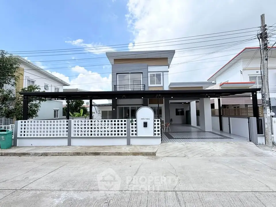 Modern two-story house with spacious driveway and sleek design in a suburban neighborhood.