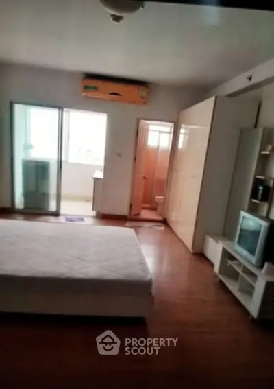 Spacious bedroom with modern amenities and wooden flooring