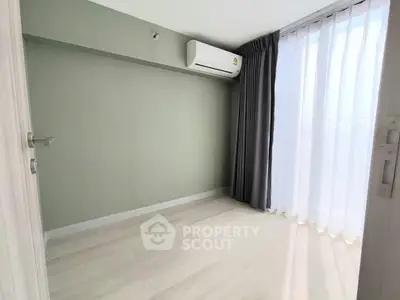 Bright empty room with air conditioning and large window, perfect for customization.