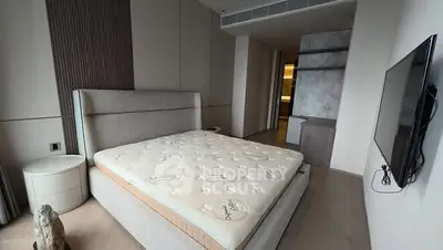 Modern bedroom with stylish decor and wall-mounted TV