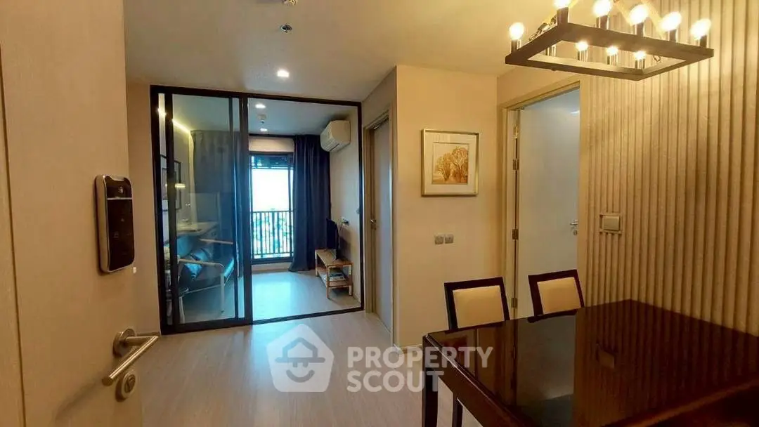 Modern apartment interior with dining area and glass partitioned room.