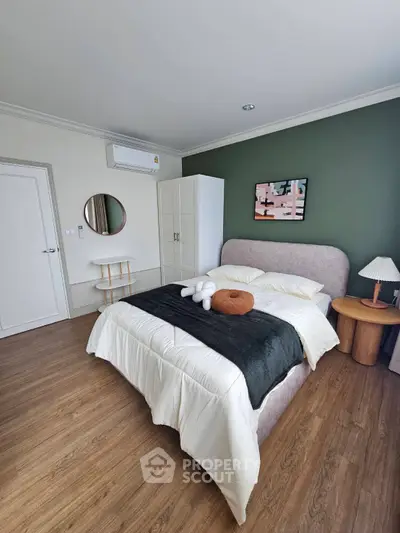 Modern bedroom with stylish decor, featuring a cozy bed, wooden flooring, and elegant furnishings.