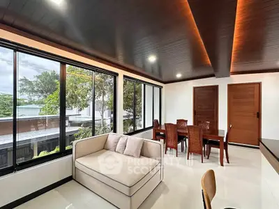 Spacious modern living room with large windows and elegant dining area