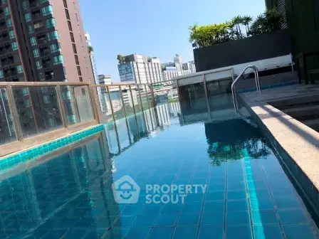 Luxurious rooftop pool with stunning city views in modern high-rise building.