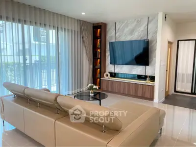 Modern living room with sleek design, large TV, and elegant furniture in a bright, airy space.