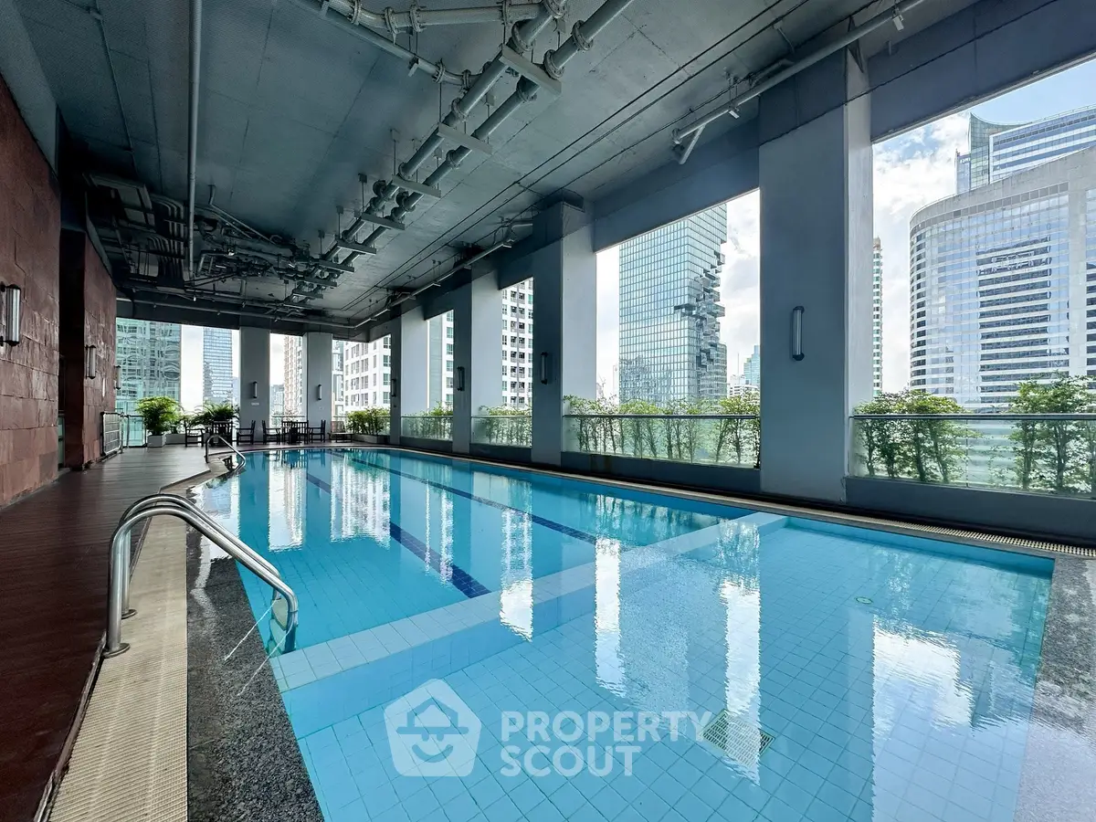 Luxurious indoor pool with stunning city views in a modern high-rise building.