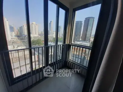 Stunning city view from a modern high-rise balcony with floor-to-ceiling windows.