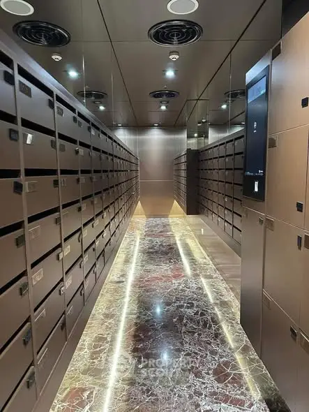 Luxurious modern building entrance with sleek mailboxes and marble flooring.